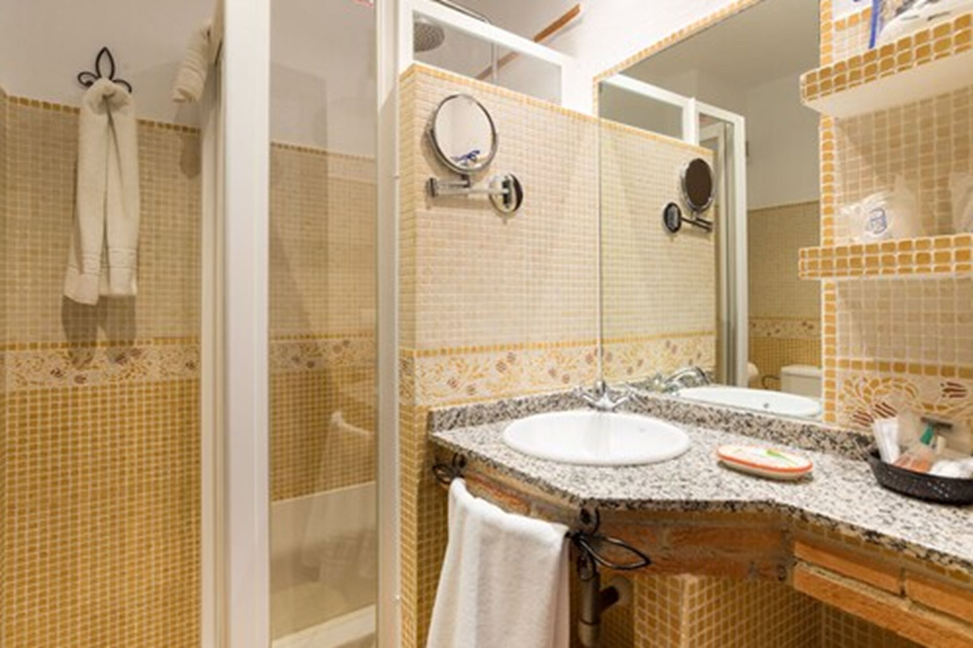 A bathroom with two sinks, a mirror, and a shower.