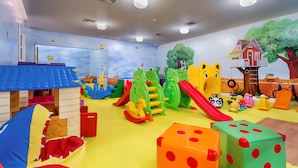Un espace de jeux pour enfants avec différents jouets et équipements de jeu.