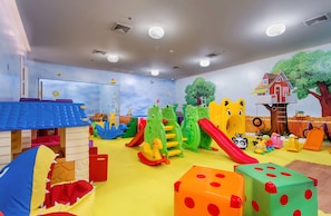 Uma área de recreação infantil com diversos brinquedos e estruturas lúdicas.