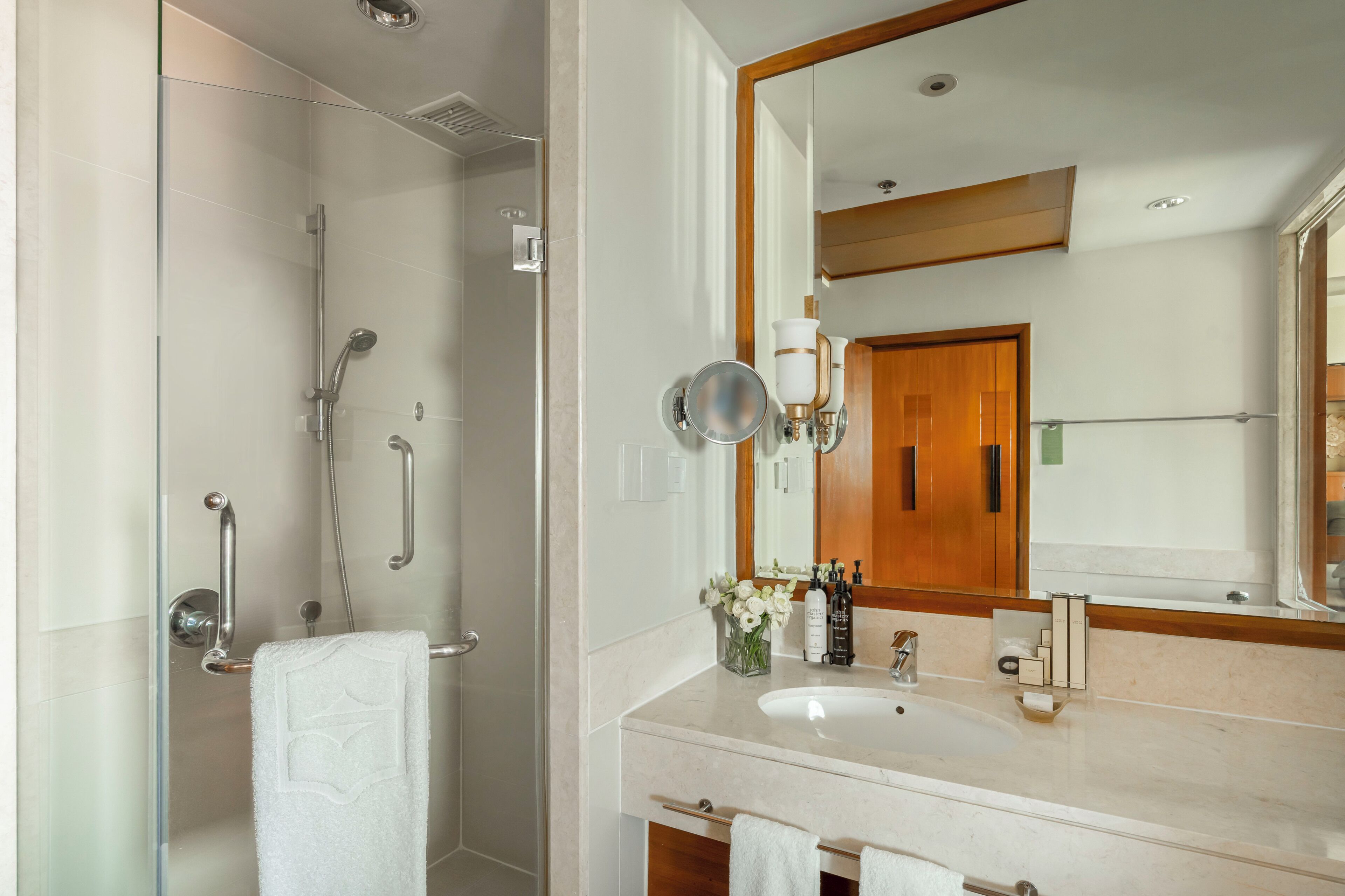 Un baño con ducha, lavabo y espejo.