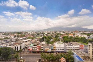 Une vue urbaine avec des bâtiments, des routes et une montagne en arrière-plan.