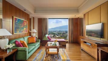 A spacious living room with a green sofa, a coffee table, and a television.