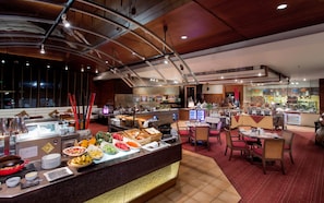Un espace buffet proposant divers plats et une zone de restauration avec des tables et des chaises.