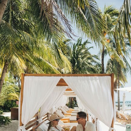 On the beach, white sand, sun loungers, beach umbrellas