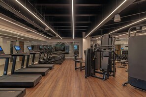 A modern gym with treadmills, weight machines, and exercise equipment.