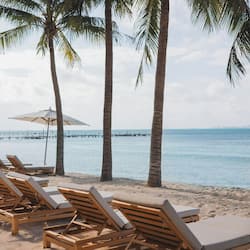 On the beach, white sand, sun loungers, beach umbrellas