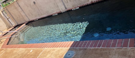 Una piscina al aire libre, sillones reclinables de piscina