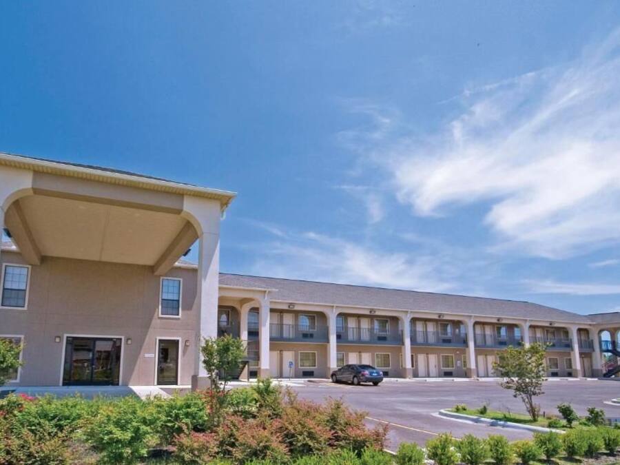 Un motel de varios pisos con entrada central y balcones.