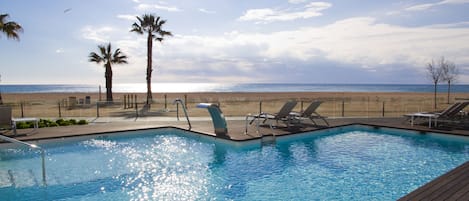 Een binnenzwembad, een buitenzwembad, parasols voor strand/zwembad