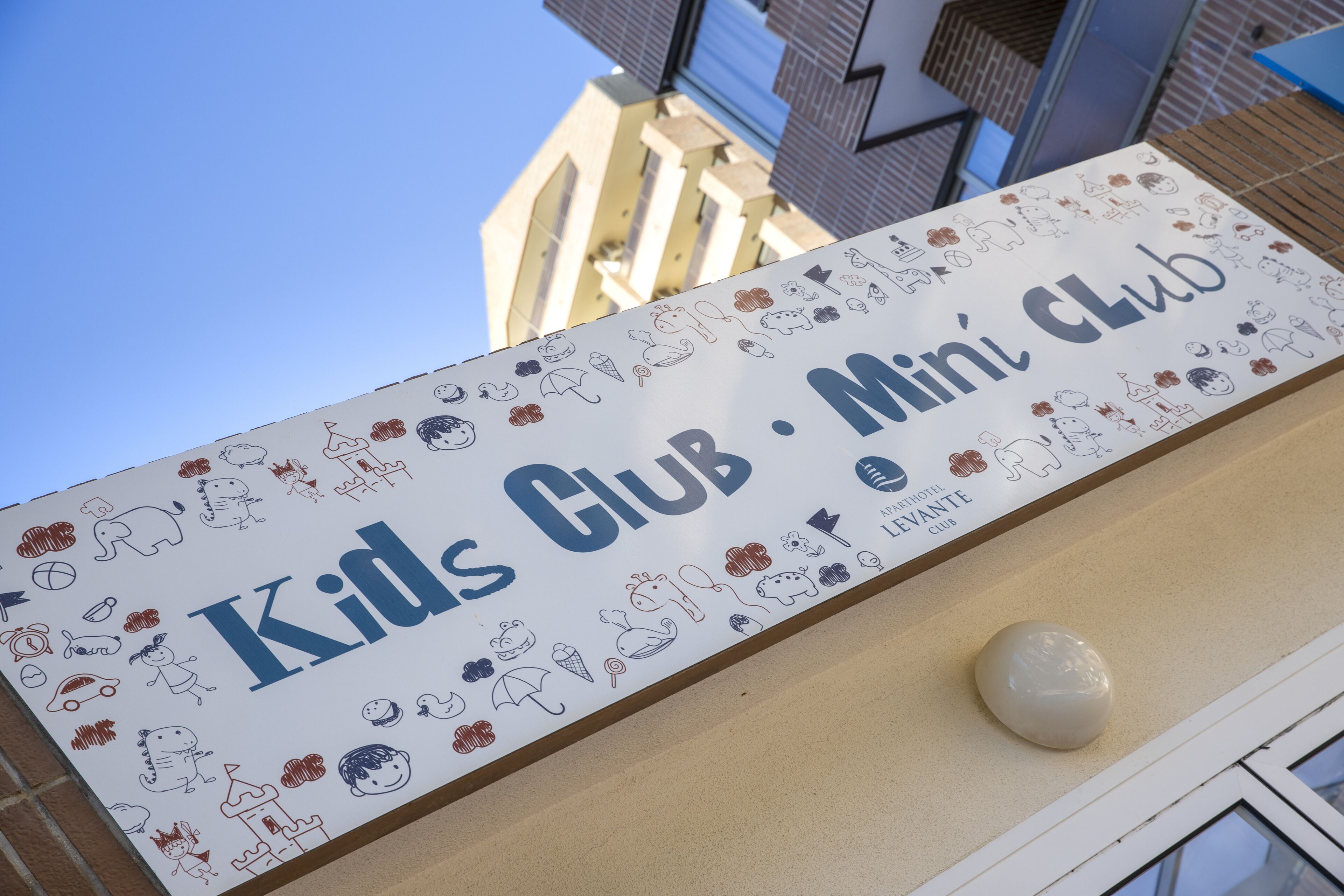 A sign for 'Kids Club' with various child-related illustrations.