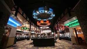 A casino interior with multiple gaming tables, a central bar area, and a distinctive circular ceiling design.