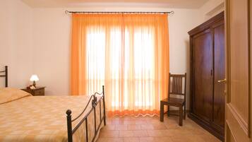 Una camera da letto con un letto, una sedia, un comodino e un armadio.