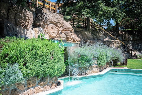 En säsongsöppen utomhuspool, parasoller och solstolar