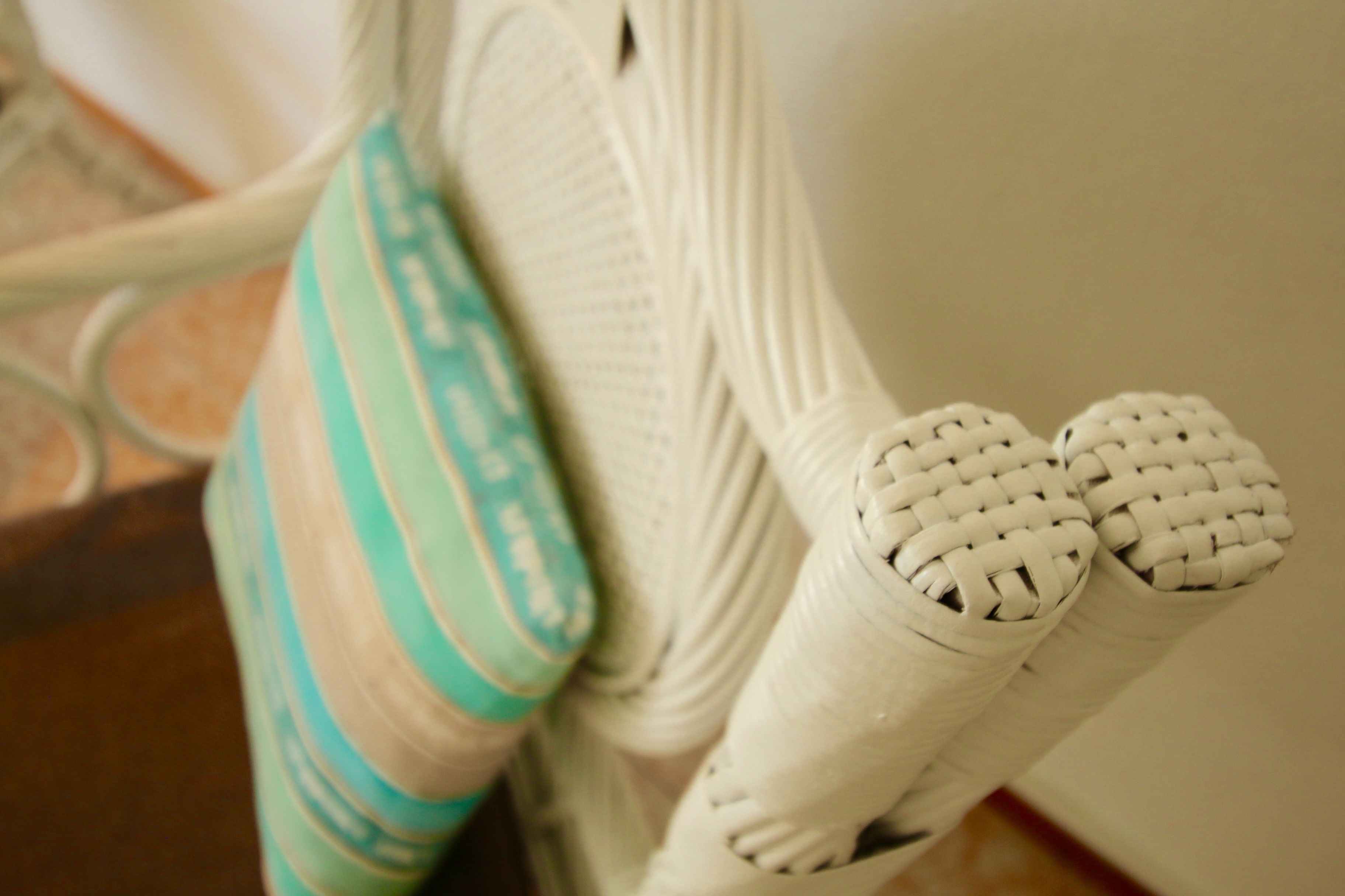 A close-up of a white woven object, possibly a part of a piece of furniture or equipment.