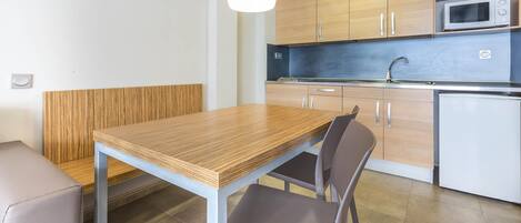 A modern kitchen with wooden cabinets, a microwave, and a sink.