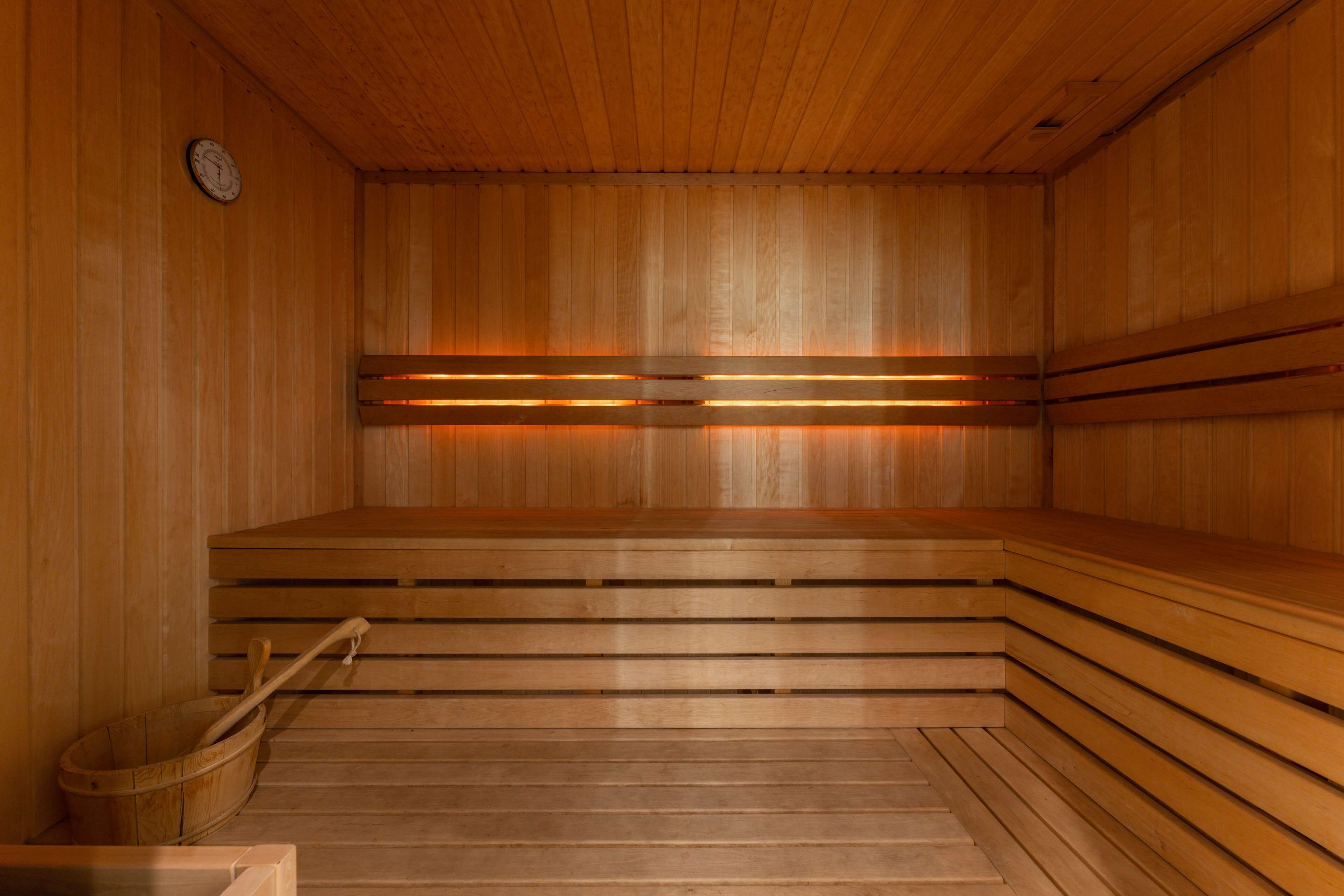 A sauna with wooden benches and benches, a wooden wall, and a wooden floor.