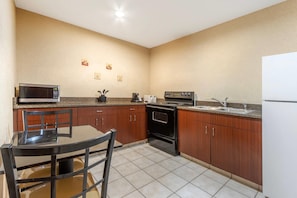 A compact kitchen with a microwave, stove, sink, and a refrigerator. - Comfort Inn & Suites Charleston Airport Convention Center (North Charleston)