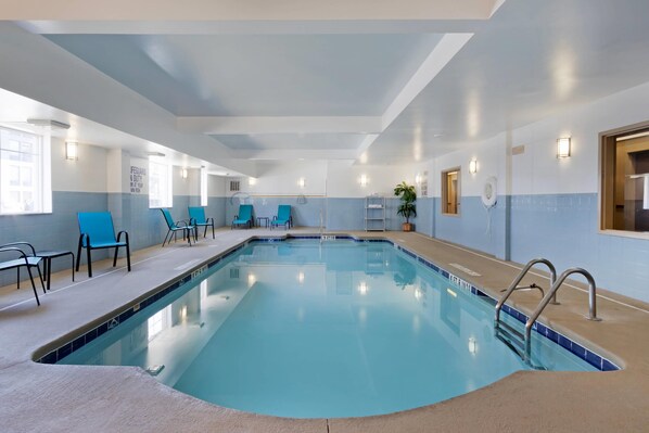 An indoor swimming pool with clear water, surrounded by blue chairs and a tiled deck. - Comfort Inn & Suites Charleston Airport Convention Center (North Charleston)