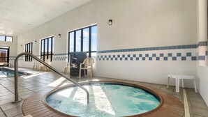 A hot tub area with a tiled floor, a wooden deck surrounding the tub, and a view of the sky through large windows. - Comfort Inn & Suites Sikeston I-55 (Sikeston)