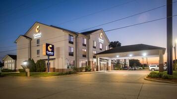 A Comfort Inn & Suites hotel with a covered parking area and a well-lit entrance.