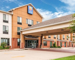 Un hôtel Comfort Inn & Suites doté d’une entrée bien visible, d’un parking couvert et d’un panneau indiquant une hauteur libre de 12 pieds.