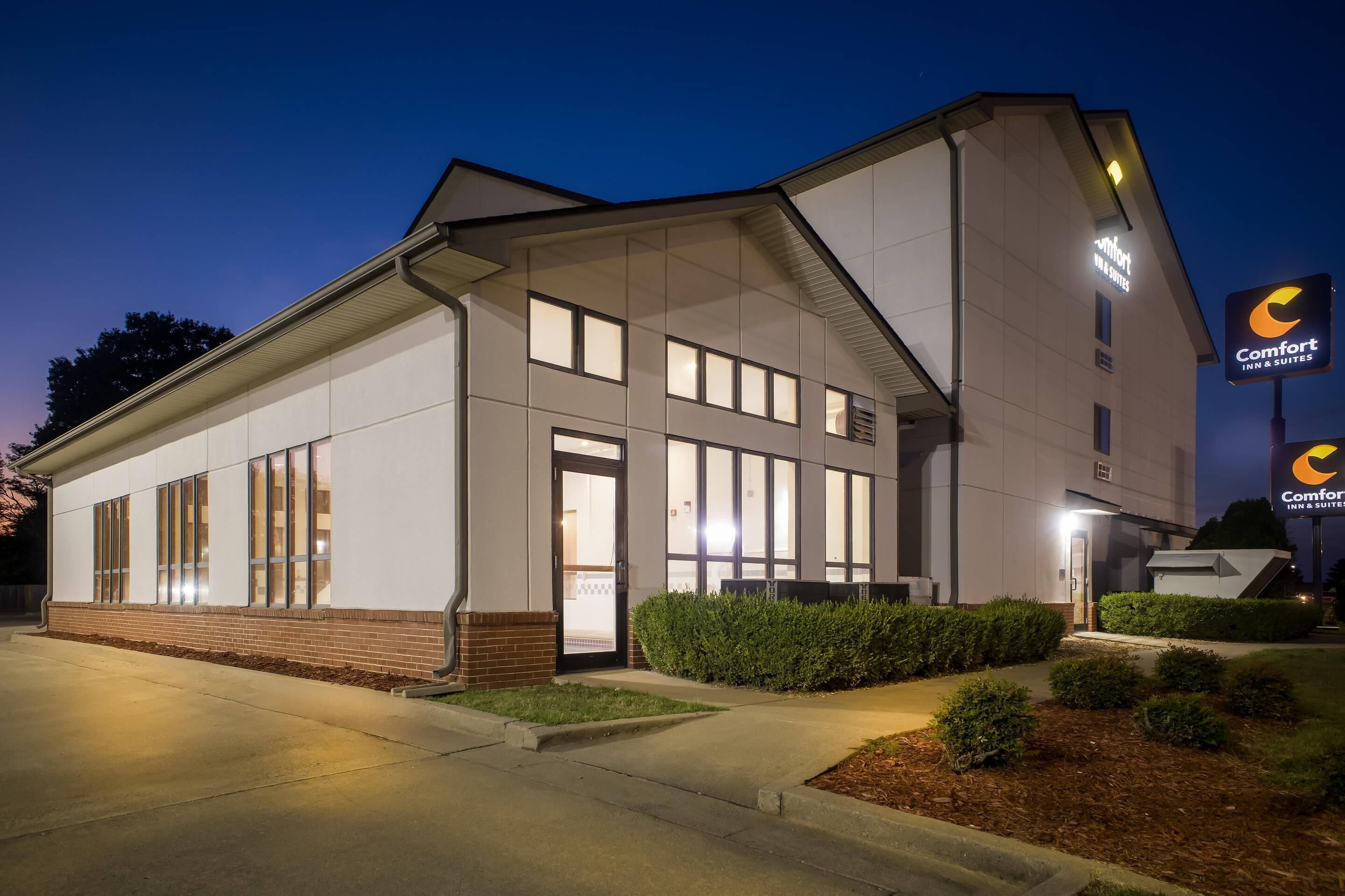 A modern hotel building with a flat roof, large windows, and a well-lit entrance.