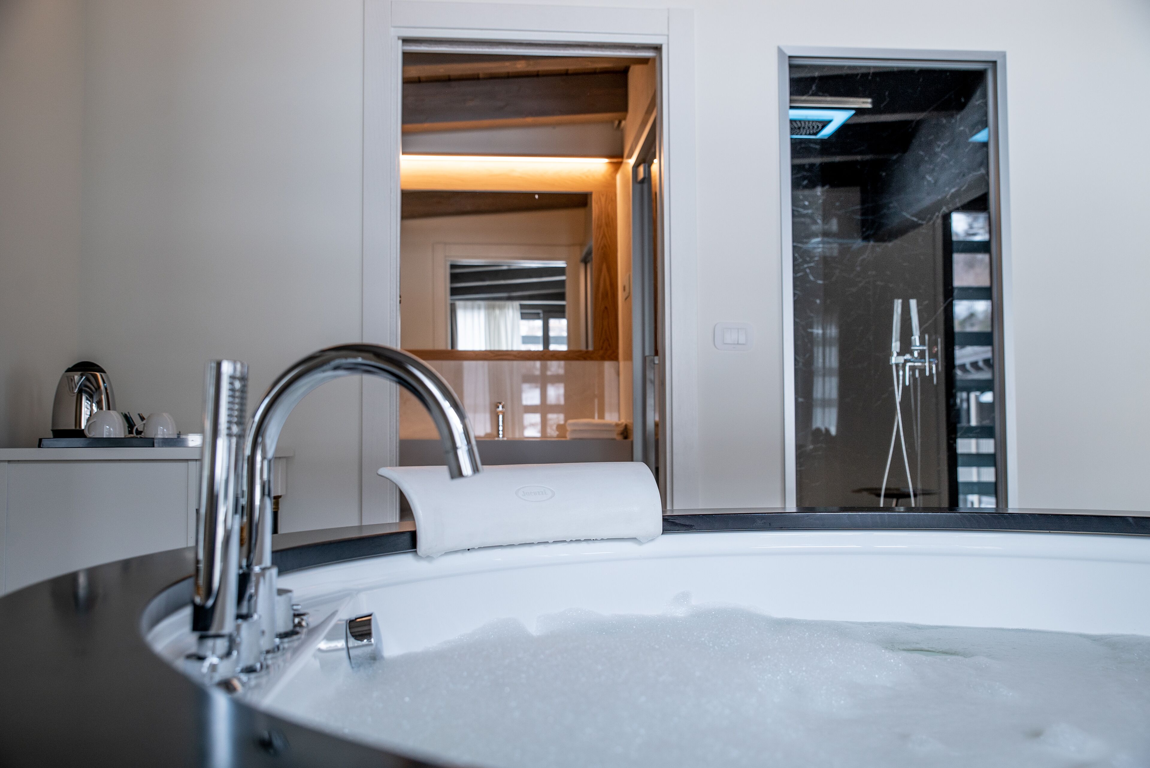 A modern bathroom with a bathtub, a sink, and a shower area.