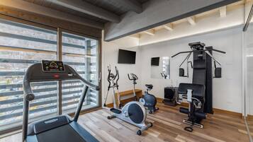 A gym with a treadmill, elliptical, stationary bike, and weight machines.