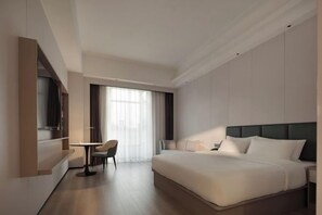 A modern hotel room with a large bed, a desk, and a chair. - Centron International Hotel (Longyan)