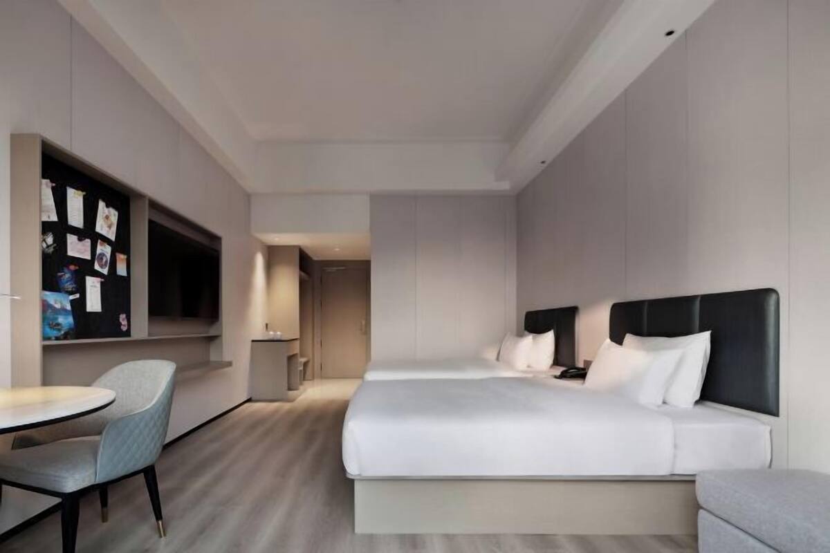 Una habitación de hotel moderna con una cama grande, un escritorio y una zona de estar.