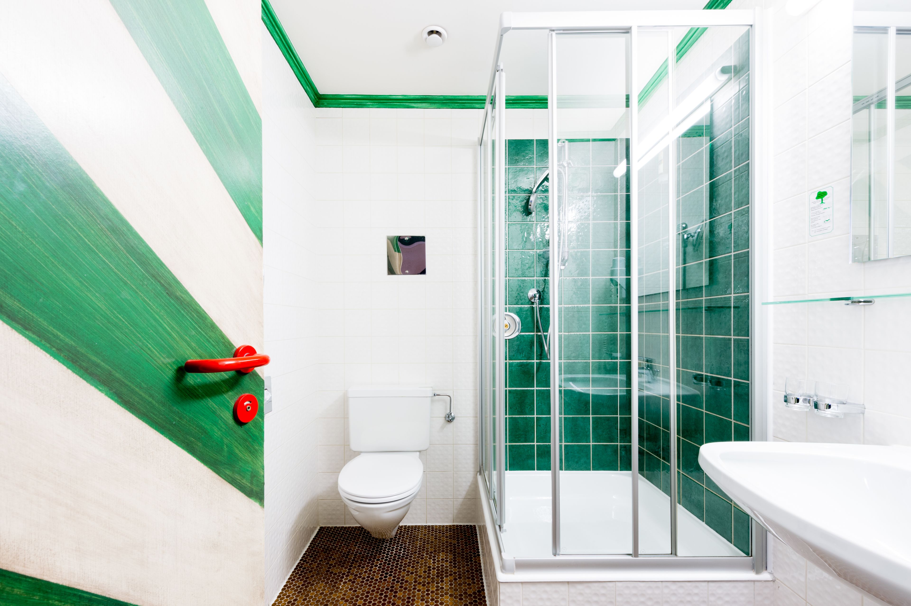 Une salle de bain avec douche, toilettes et lavabo.