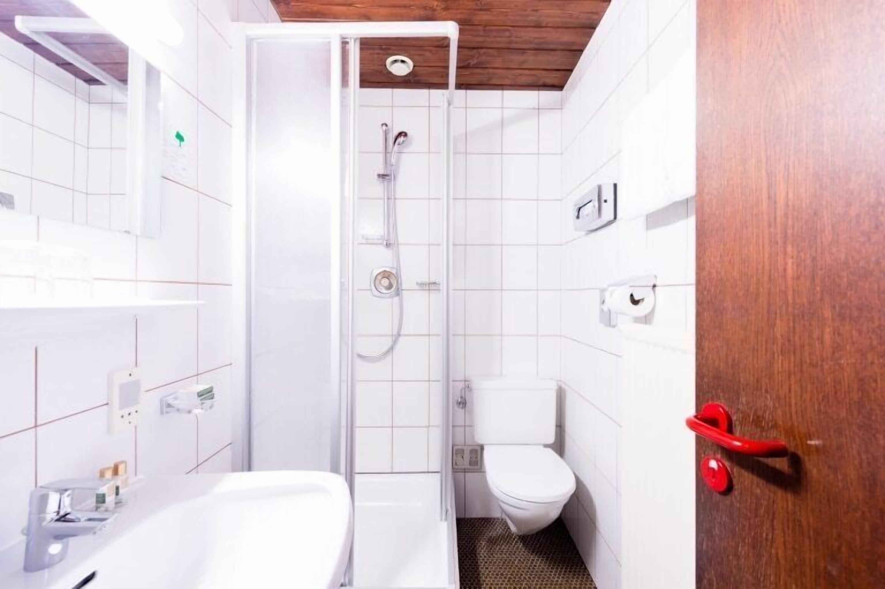 A bathroom with a shower, toilet, and bathtub.