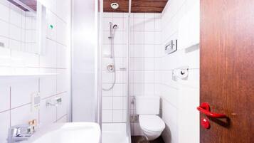 A bathroom with a shower, toilet, and bathtub.