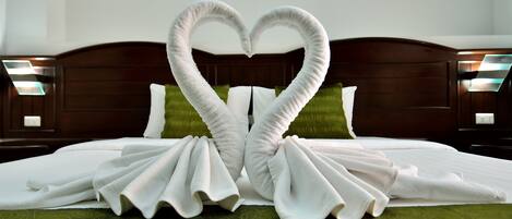 Una cama con una colcha verde y dos almohadas blancas.
