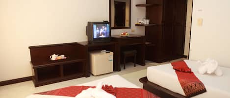 Une chambre d’hôtel avec deux lits, une télévision, un bureau et un petit réfrigérateur.