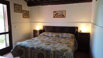 Una camera da letto con un letto grande, due comodini con lampade e tre quadri appesi al muro.