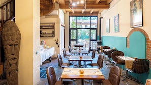 A restaurant with wooden beams, tables with chairs, and a view through large windows. - Boutique Hotel Scalzi - Adults Only (Verona)