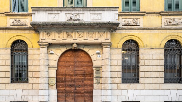 A historic building facade with a large wooden door, arched windows, and decorative stonework. - Boutique Hotel Scalzi - Adults Only (Verona)