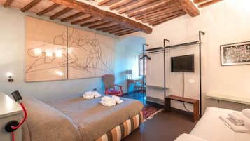Une chambre d’hôtel avec un lit, une banquette, une chaise, un téléviseur et un grand tableau abstrait accroché au mur.