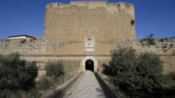 A stone fortress with a central arched entrance and a crest above it.