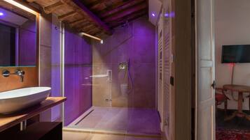 Une salle de bain moderne avec une douche à parois de verre, un meuble-lavabo en bois et un grand miroir.