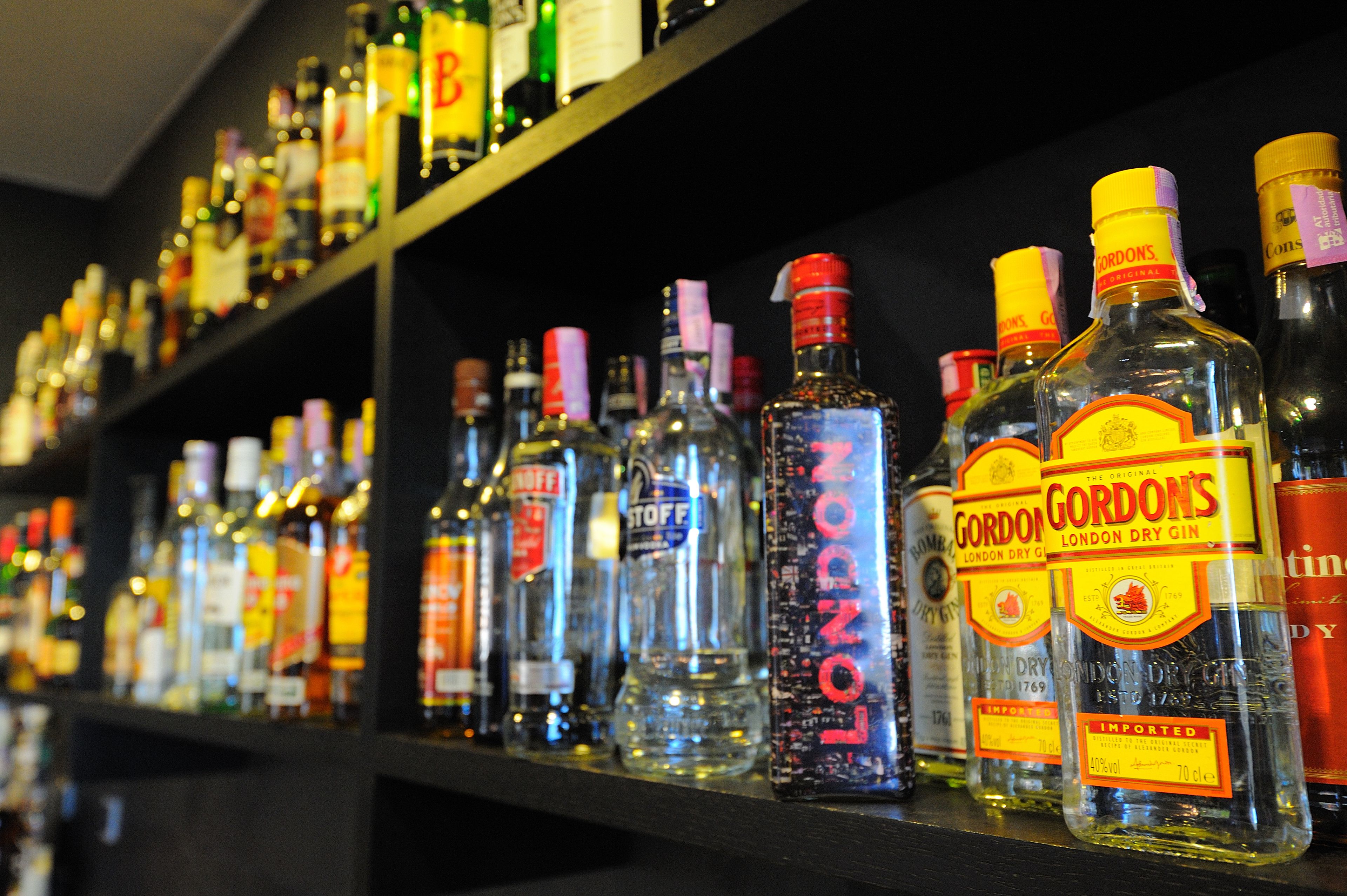 A shelf with various bottles of alcohol, including Gordon's London Dry Gin.
