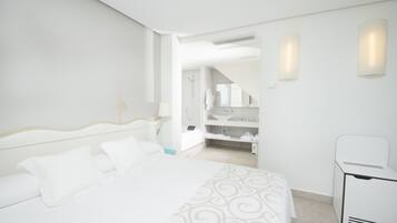 Une chambre d’hôtel comprenant un lit, une chaise, une salle de bain avec douche et des toilettes.