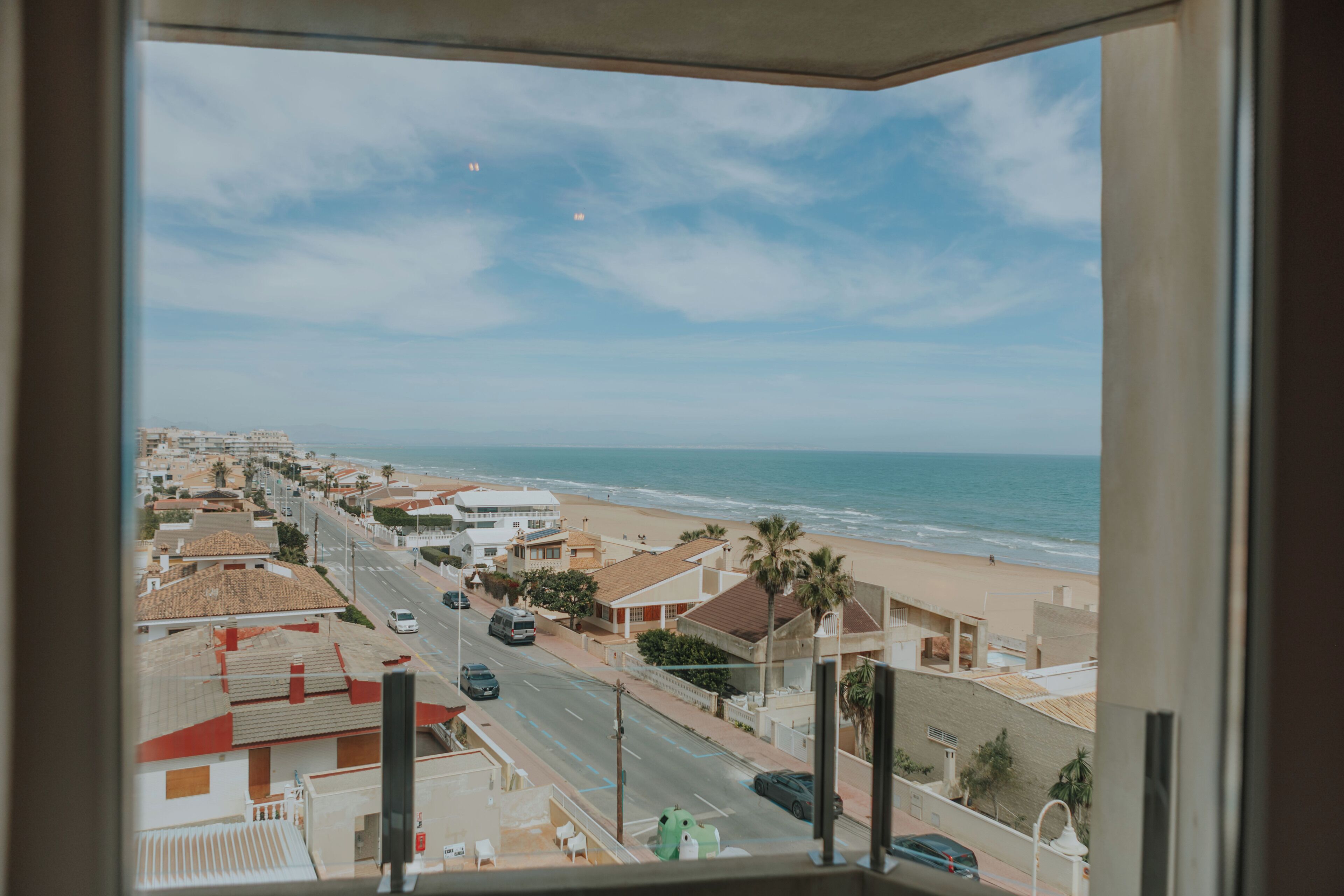 A coastal cityscape with buildings, a beach, and the ocean.