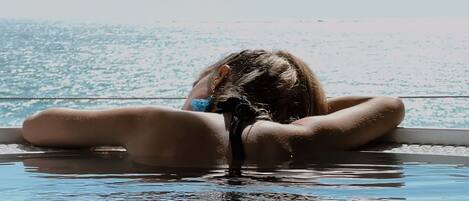 Une personne dans une piscine avec vue sur la mer.