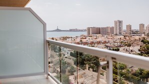 A balcony with a view of a coastal cityscape, including buildings and a lighthouse. - Hotel Las Gaviotas (Cartagena)