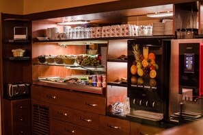 A buffet area with various food items, a beverage dispenser, and a coffee machine. - Hotel Victoria (Plzen)