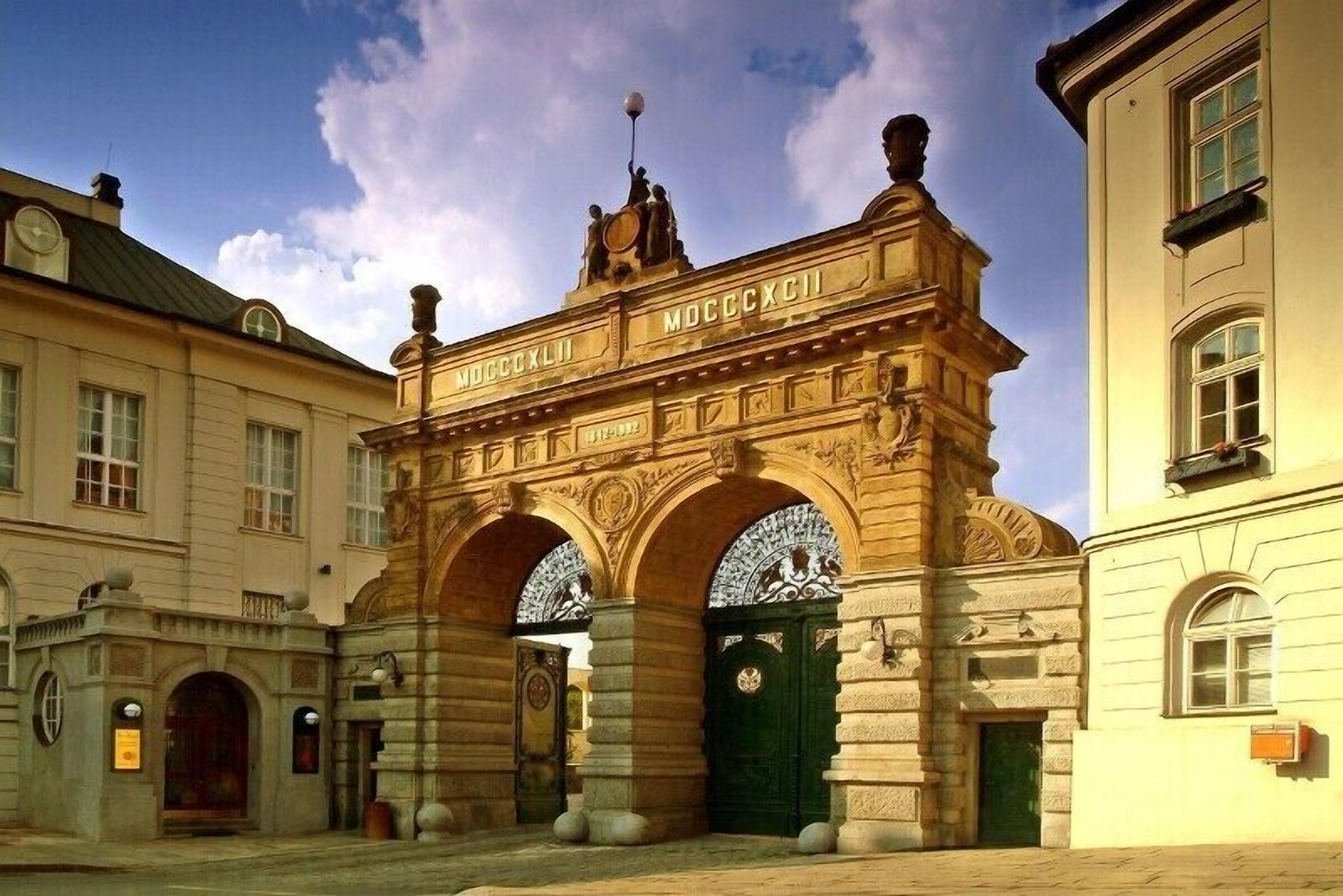 A historic building with ornate architecture, including a prominent archway with inscriptions.