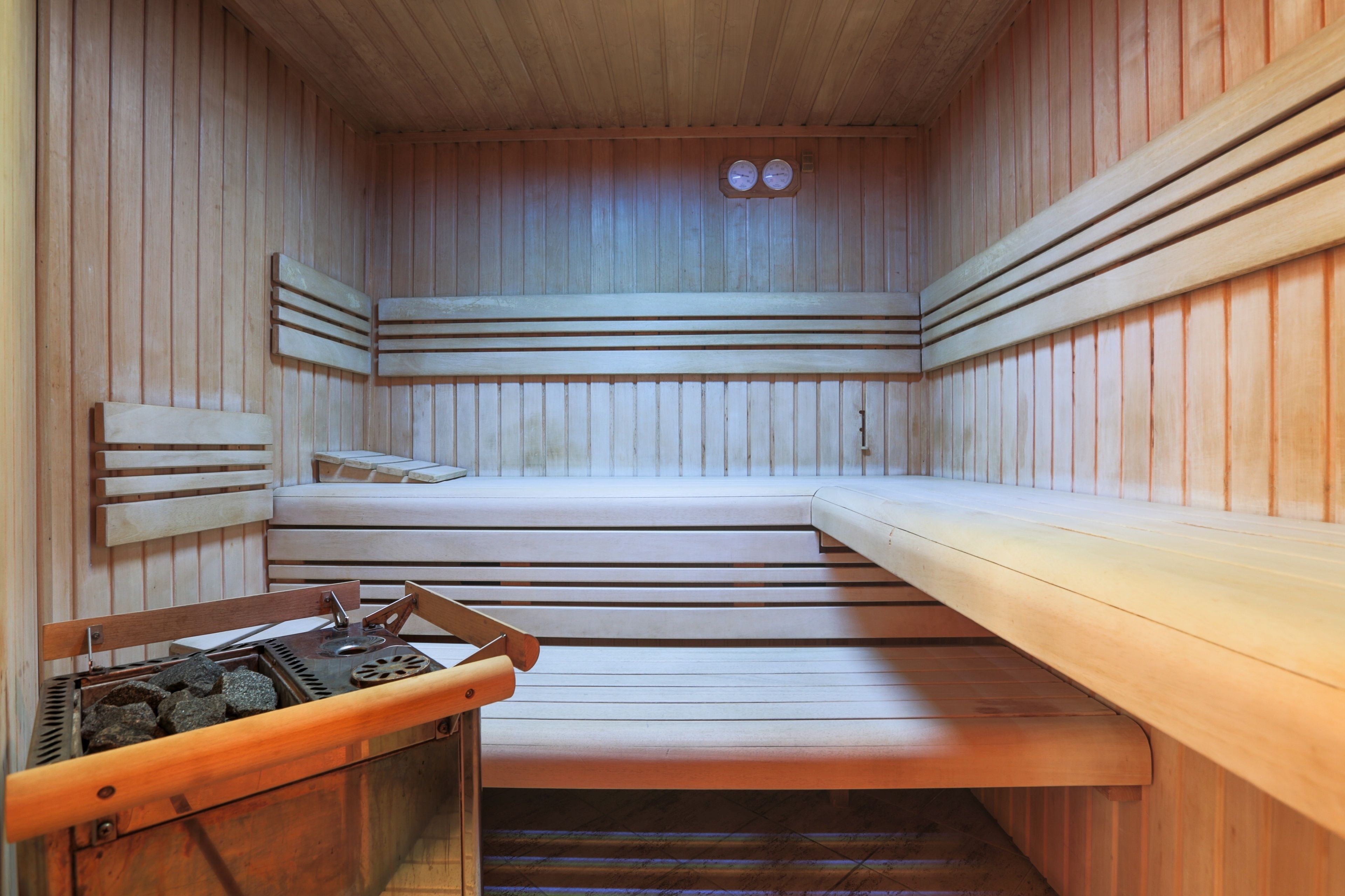 Una sauna amb bancs de fusta i un generador de vapor.