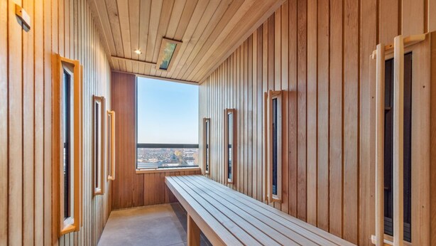 A wooden interior hallway with benches and windows.